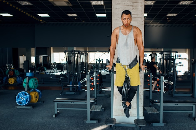 Atleta fazendo flexões nas barras irregulares da academia