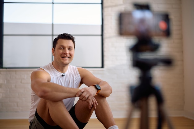 Atleta feliz grabando un vlog sobre su rutina de entrenamiento