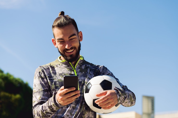 Foto atleta feliz sorrindo olhando para o celular