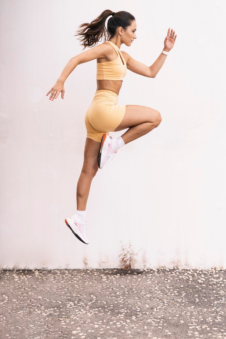 Foto atleta femenina aislada saltando al aire libre