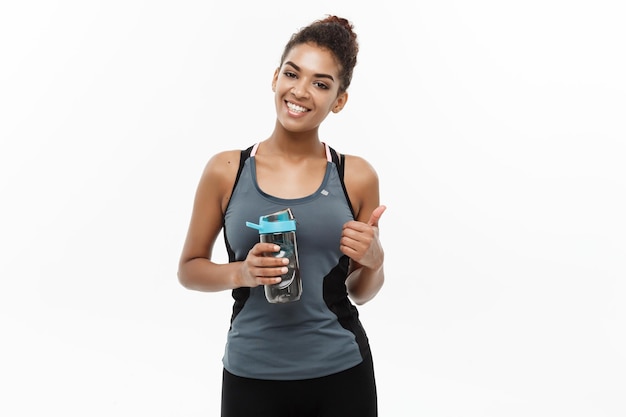 Foto atleta femenina con una botella de agua contra un fondo blanco