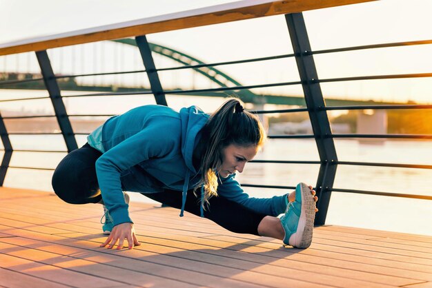 Foto atleta femenina estirándose al aire libre