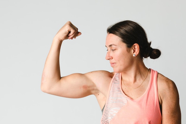 Foto atleta femenina flexionando sus brazos