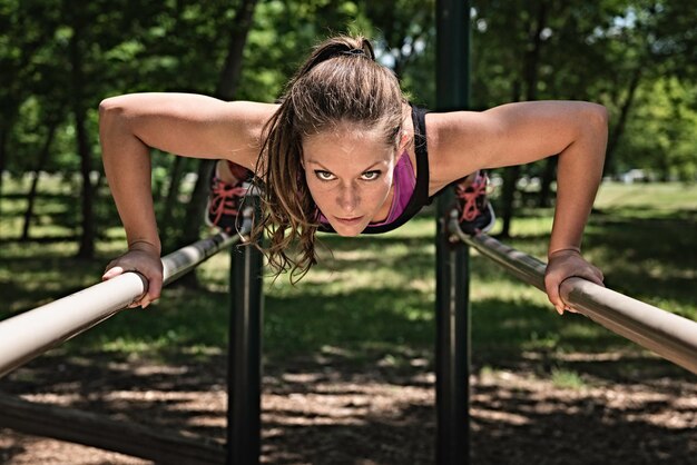 Atleta femenina haciendo ejercicio en barras paralelas