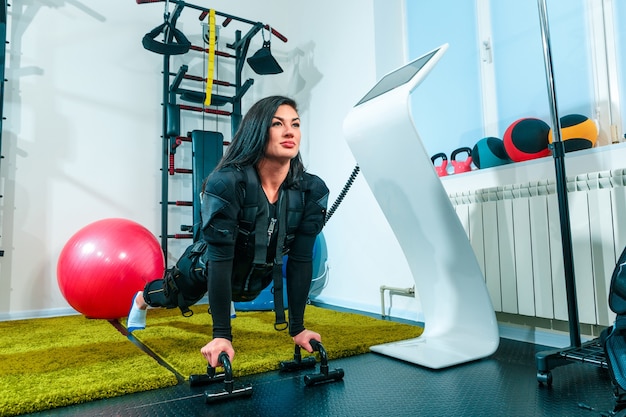 La atleta femenina haciendo ejercicio en el gimnasio EMS