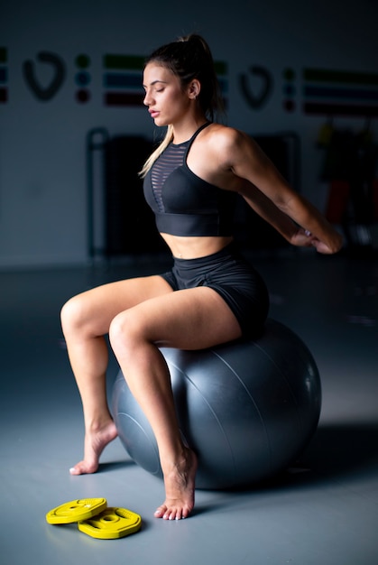 Atleta femenina joven que se extiende en el gimnasio