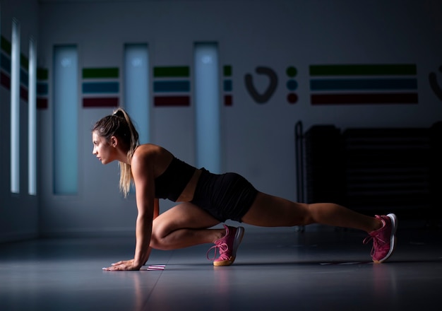 Atleta femenina joven que se extiende en el gimnasio