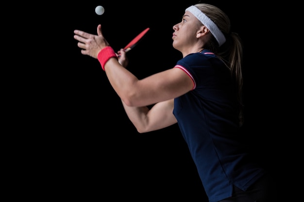 Atleta femenina jugando ping pong en negro