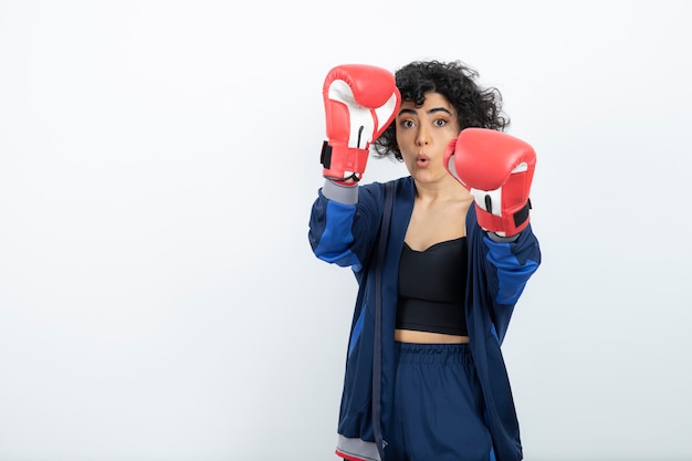 Foto atleta femenina de pelo rizado en la formación de guantes rojos.