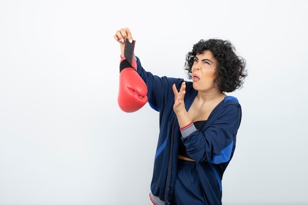 Atleta femenina de pelo rizado con guantes de boxeo.