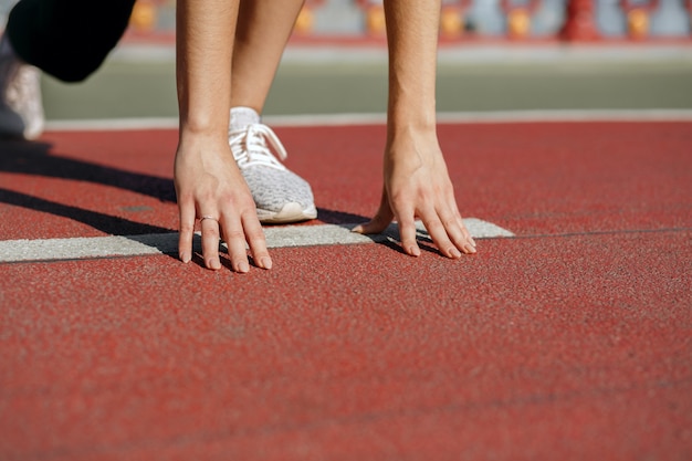 Atleta femenina en posición inicial lista para la carrera. Espacio para texto