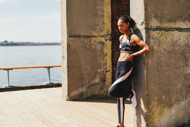Atleta feminina apoiada na parede