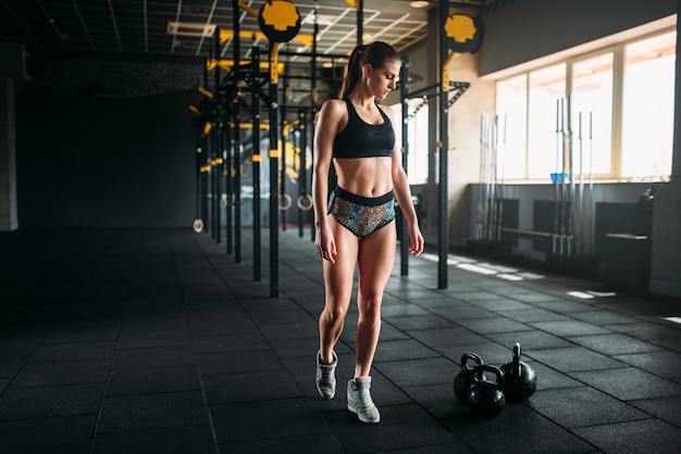 Atleta feminina com corpo musculoso posando no ginásio