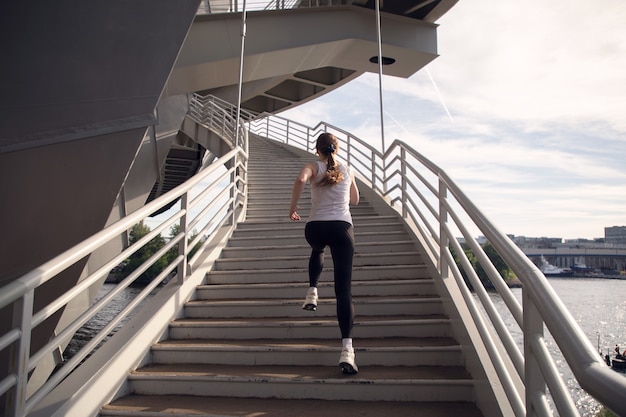 Atleta feminina correndo escada rolante