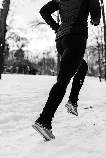 Atleta feminina correndo no parque em dia de inverno no parque