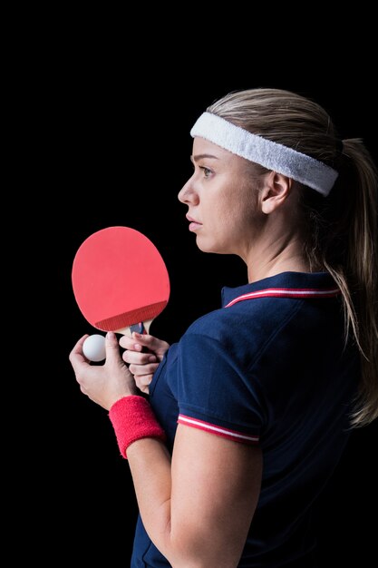 Atleta feminina jogando pingue-pongue em preto