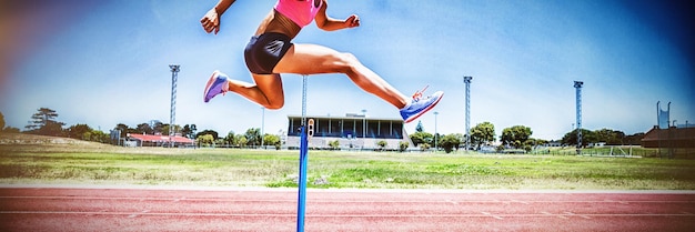 Atleta feminina pulando acima da barreira