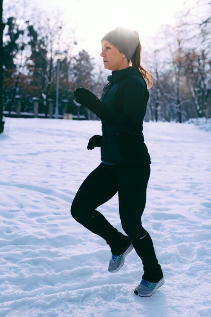 Atleta feminina se exercitando no parque em dia de inverno no parque