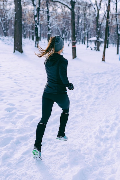 Atleta feminina se exercitando no parque em dia de inverno no parque