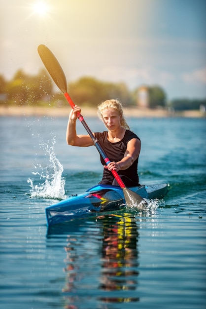 Atleta feminina treinando caiaque no lago