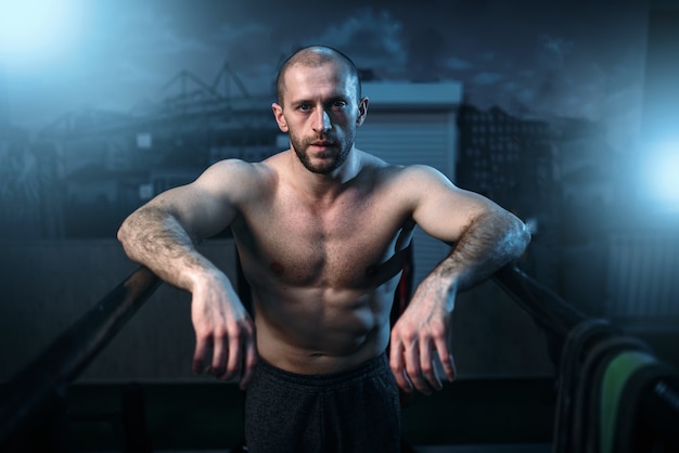 Atleta forte em barras de ginástica no ginásio