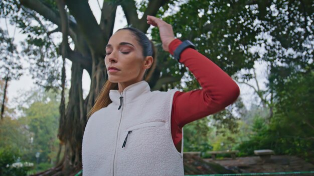 Atleta garota aquecimento parque verde preparando-se para o treino closeup mulher fitness