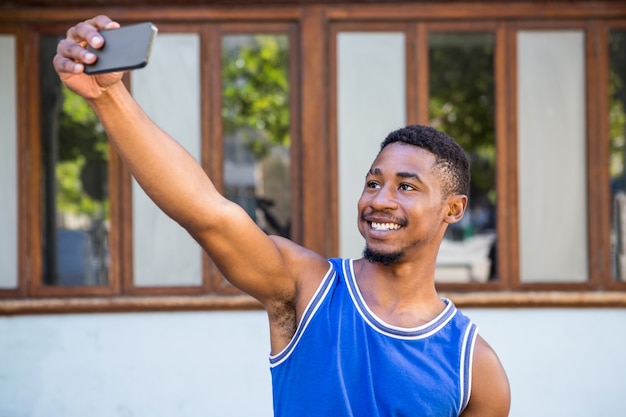 Un atleta guapo feliz tomando un selfie