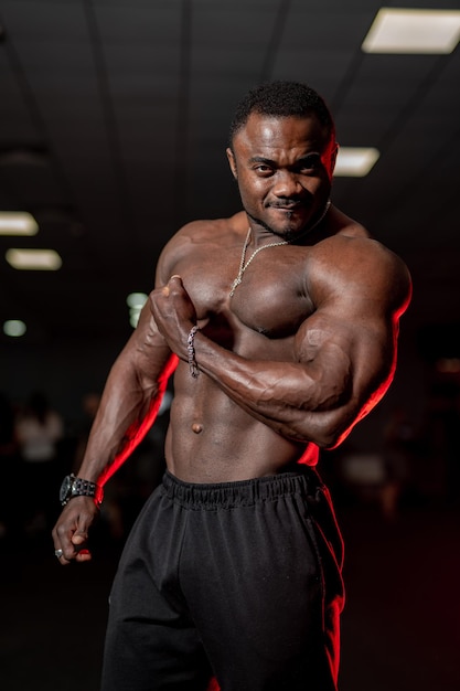 Atleta haciendo ejercicio para bíceps Atleta africano en el gimnasio