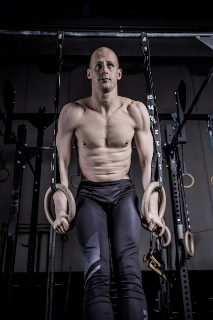 Atleta haciendo push up con anillos en el gimnasio