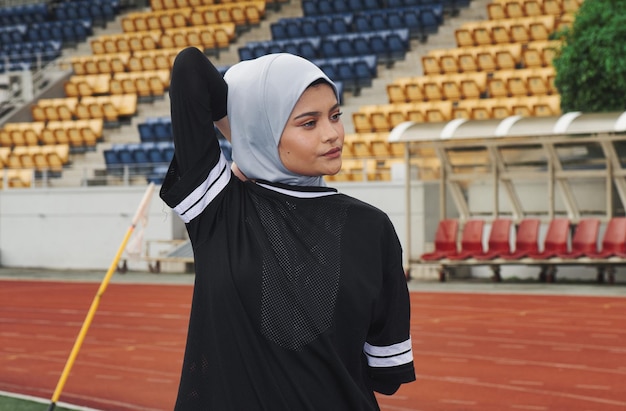 Foto atleta con hijab mientras hace ejercicio en una pista deportiva