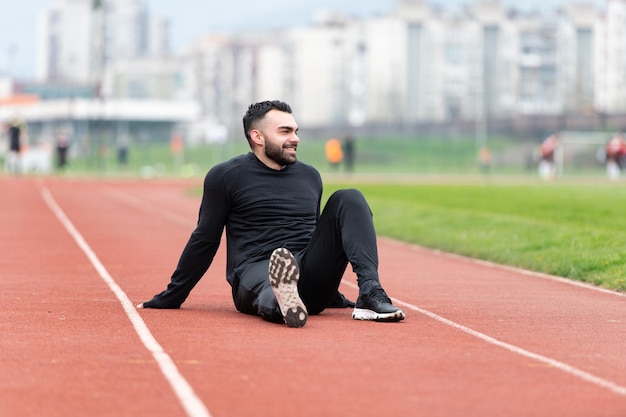 Atleta hombre descansando después de correr afuera