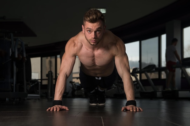 Atleta jovem adulto fazendo flexões como parte do treinamento de musculação