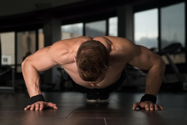 Foto atleta jovem adulto fazendo flexões como parte do treinamento de musculação