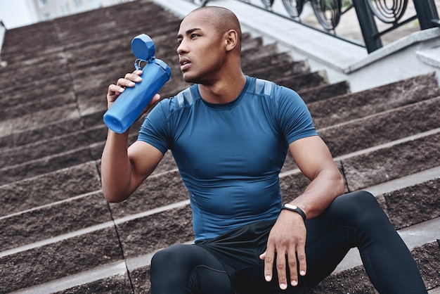 Atleta joven corredor masculino entrenando y haciendo ejercicio al aire libre en