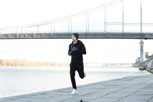 Atleta joven serio corriendo al aire libre en otoño