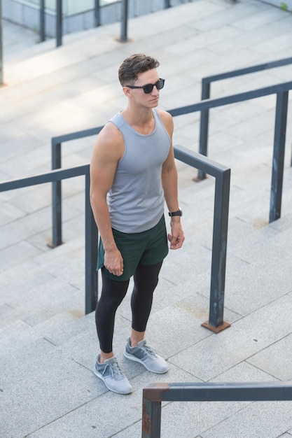 Foto atleta legal em roupas esportivas do lado de fora homem atleta em roupas esportivas na rua