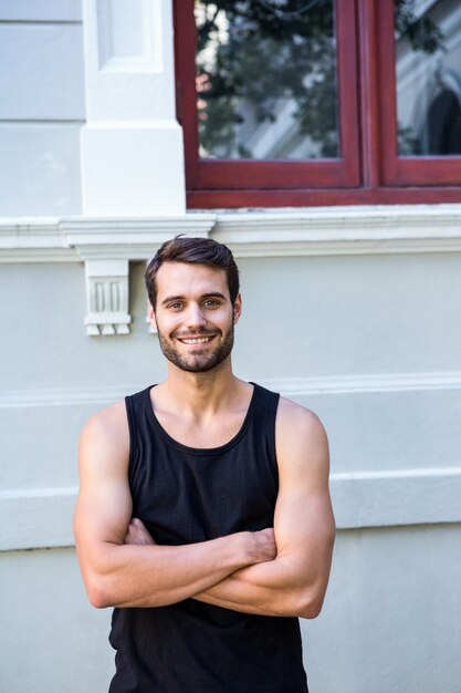 Atleta lindo e sorridente em frente a um prédio