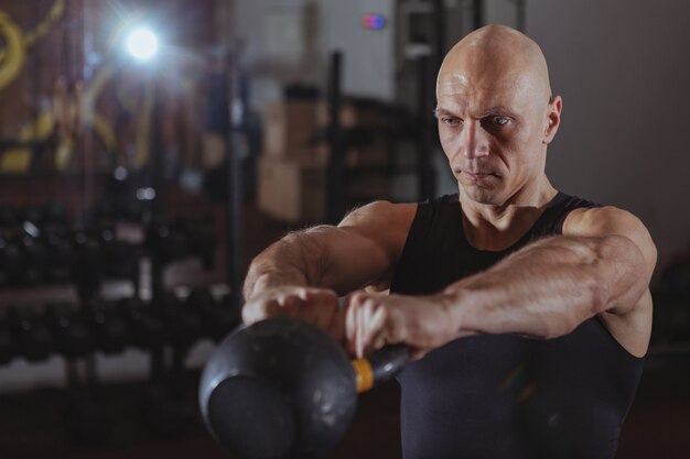 Atleta maduro do crossfit que exercita com kettlebell