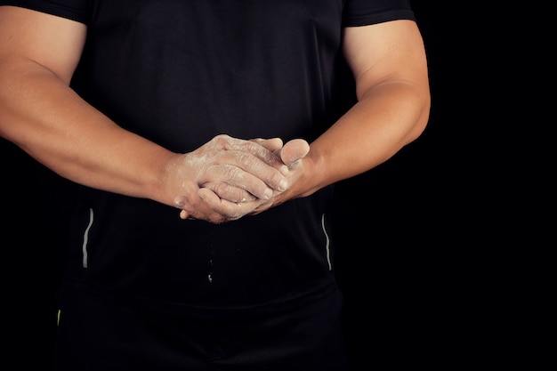 Atleta masculino adulto frota polvo blanco con magnesia antes de eventos deportivos