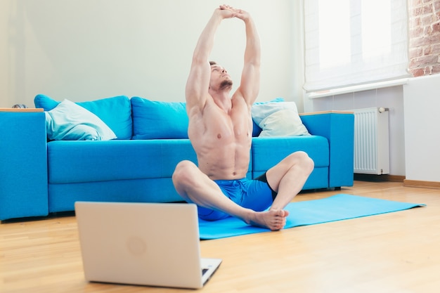 atleta masculino en casa haciendo fitness en línea