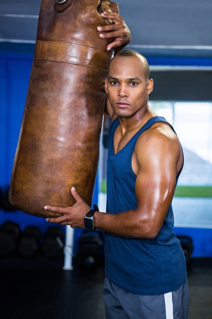 Atleta masculino confiado por saco de boxeo