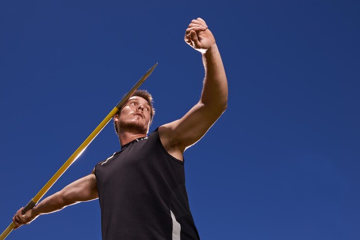Foto atleta masculino e arremesso de dardo para competição esporte com força de braço para desempenho prática desafio ou céu azul pessoa masculina bastão e alvo alvo ou atividade ao ar livre profissional ou campeão