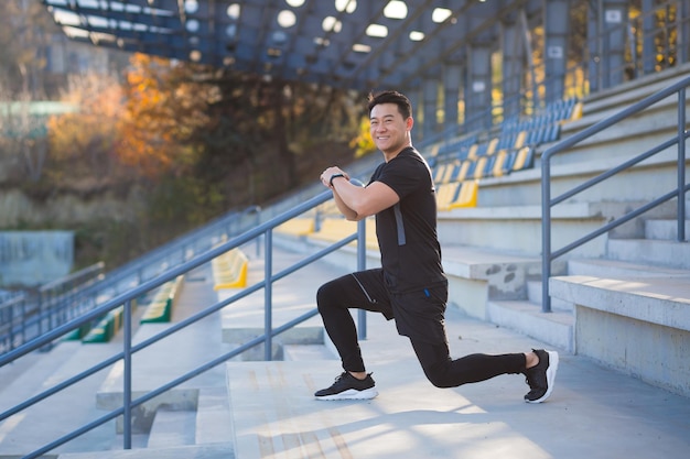 El atleta masculino entrena en una mochila fitness asiático realiza ejercicios fuera del estadio por la mañana