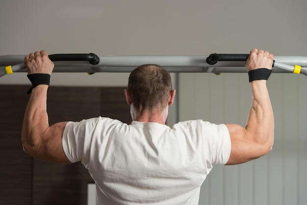 Atleta masculino fazendo pull ups chinups no ginásio