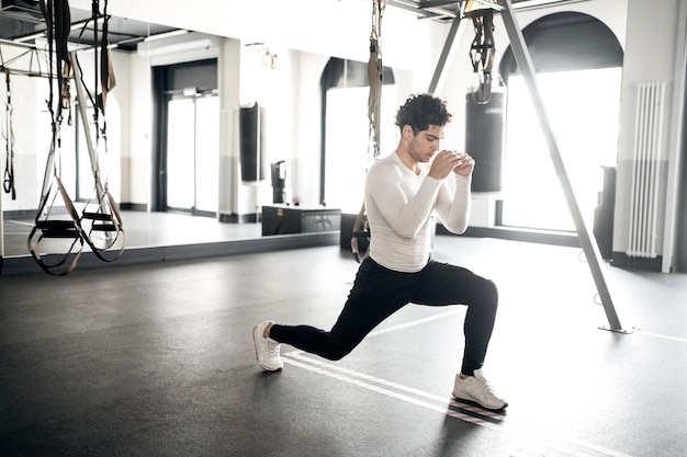 Un atleta masculino hace ejercicios de cardio entrenando en el gimnasio.