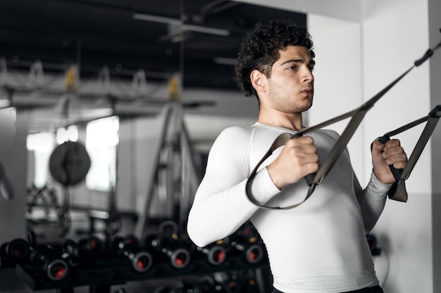 Un atleta masculino hace los ejercicios cardiovasculares correctos en el gimnasio