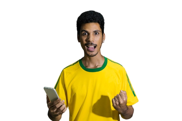 Atleta masculino o fan en uniforme amarillo mirando teléfono celular aislado