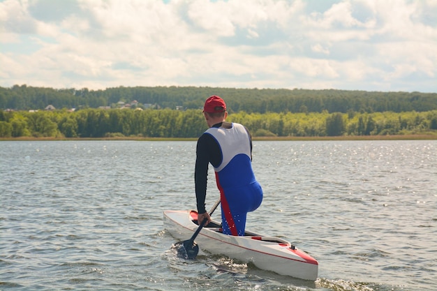 Foto atleta masculino. un piragüista rema en una canoa sobre el agua, un atleta. canoa deportiva sprint