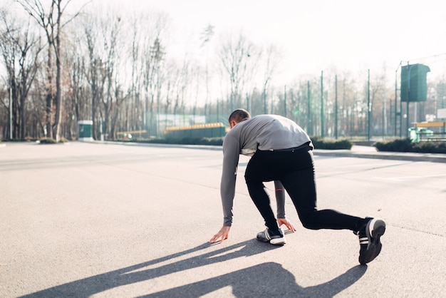 Atleta Masculino se prepara para correr en el parque de otoño