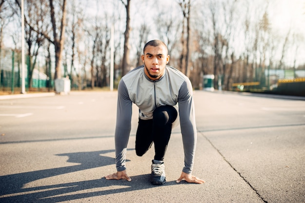 Atleta Masculino se prepara para correr en el parque de otoño